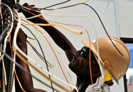 Auf diesem Foto sehen Sie einen Elektroniker bei der Arbeit